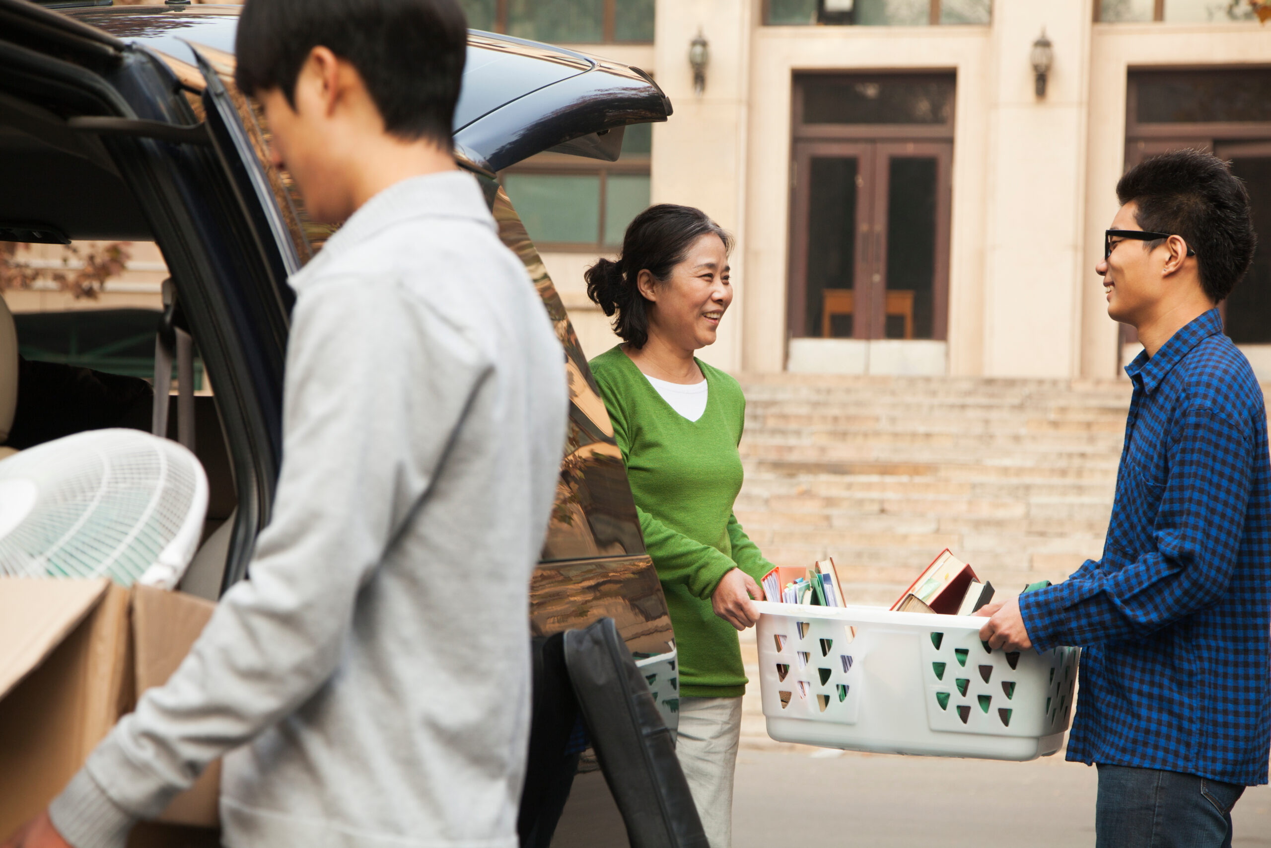 Family moving their son into dormitory on college campus